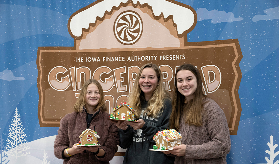 Girls standing in front of the Gingerbread Junction event sign
