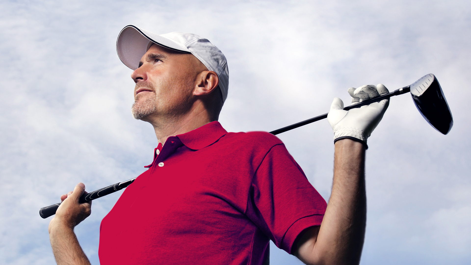 Photo of a man holding a golf club behind his shoulders